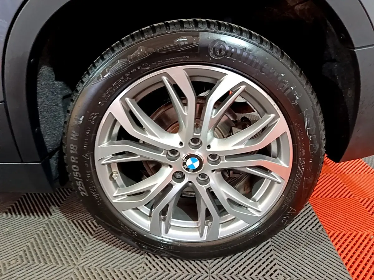 Gros plan sur la roue avant droite du BMW X2 gris foncé, mettant en valeur la jante alliage à multiples branches.