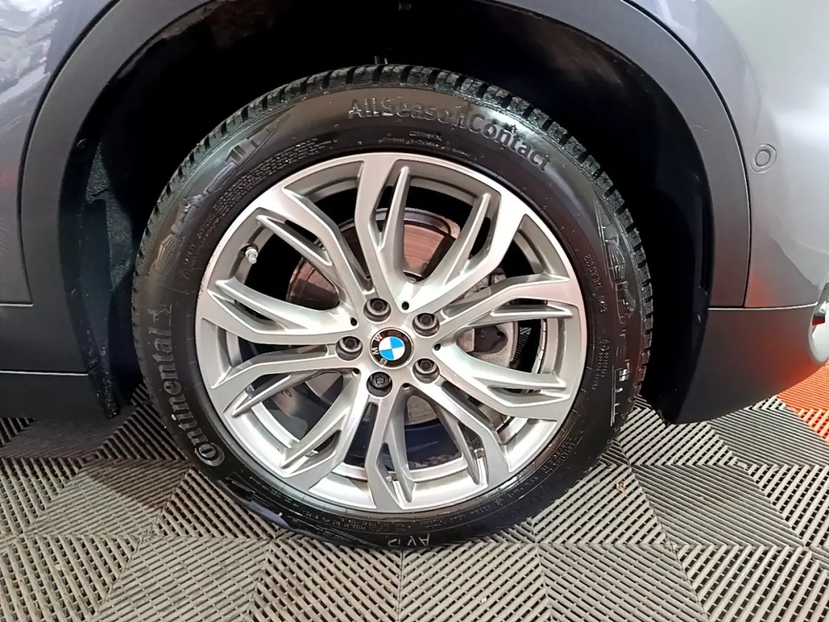 Gros plan sur la roue avant droite gris foncé d’un BMW X2 2021 avec jante alliage et pneu Continental AllSeasonContact.