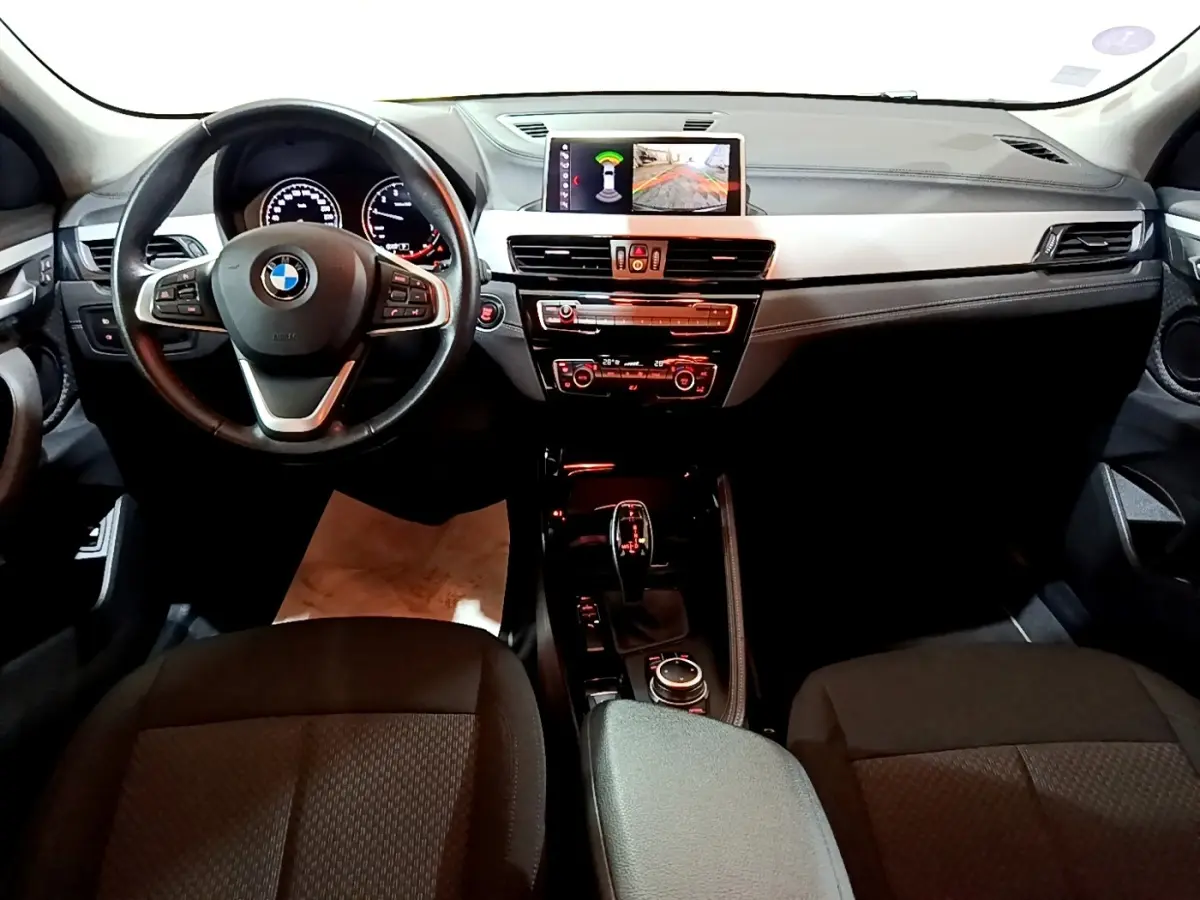 Intérieur BMW X2 sDrive18i 2021 vue avant, tableau de bord noir avec écran central et volant cuir multifonctions.