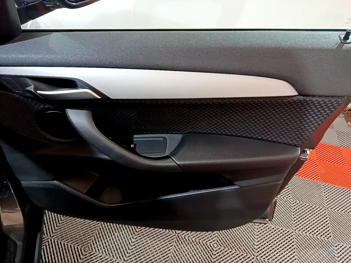 Gros plan sur la porte intérieure côté gauche de la BMW X2 sDrive18i Lounge 2021 avec insert gris et tissu texturé.