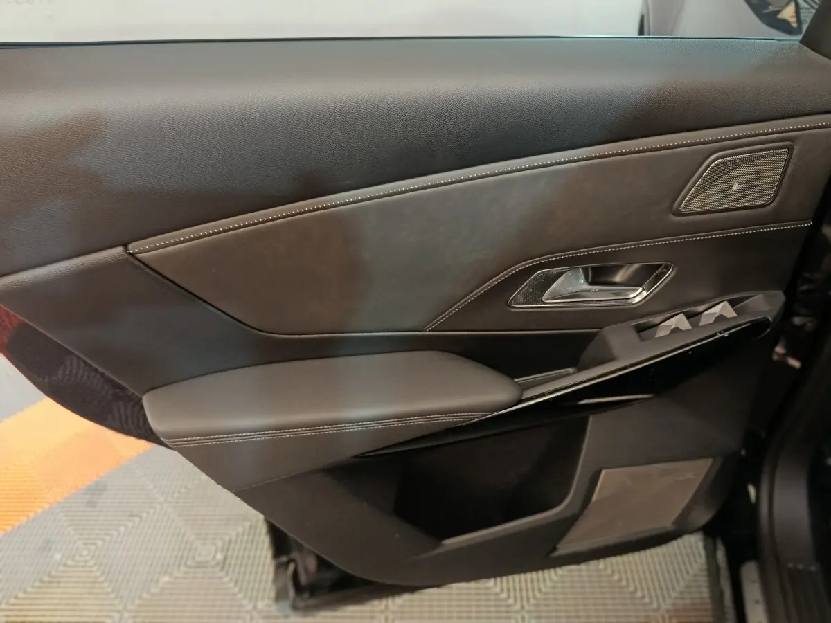 Vue rapprochée de la porte intérieure côté gauche en cuir noir avec surpiqûres blanches et haut-parleur intégré du DS7 Crossback E-TENSE 2022.