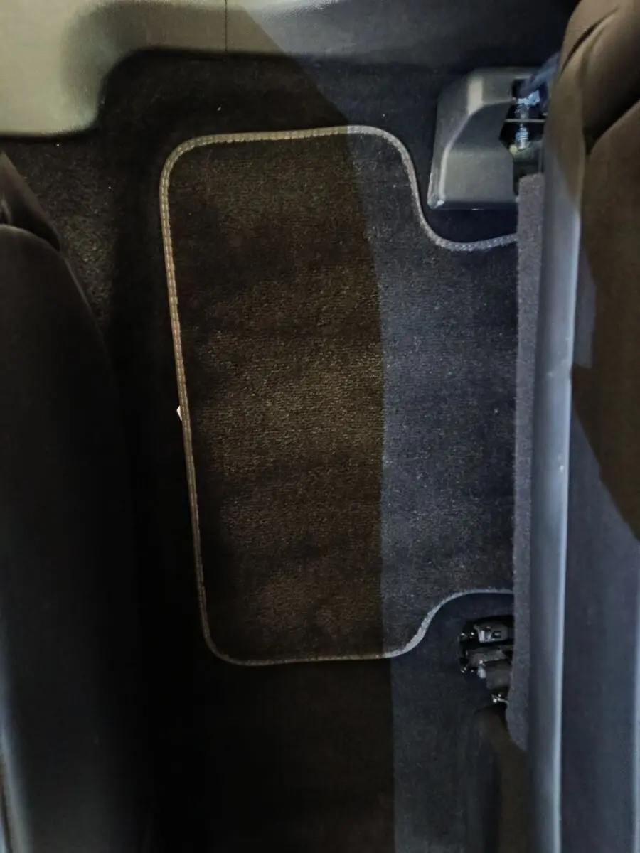 Vue rapprochée du tapis de sol arrière noir du DS7 Crossback E-TENSE 4x4 300 LOUVRE, avec partie de l'assise visible.