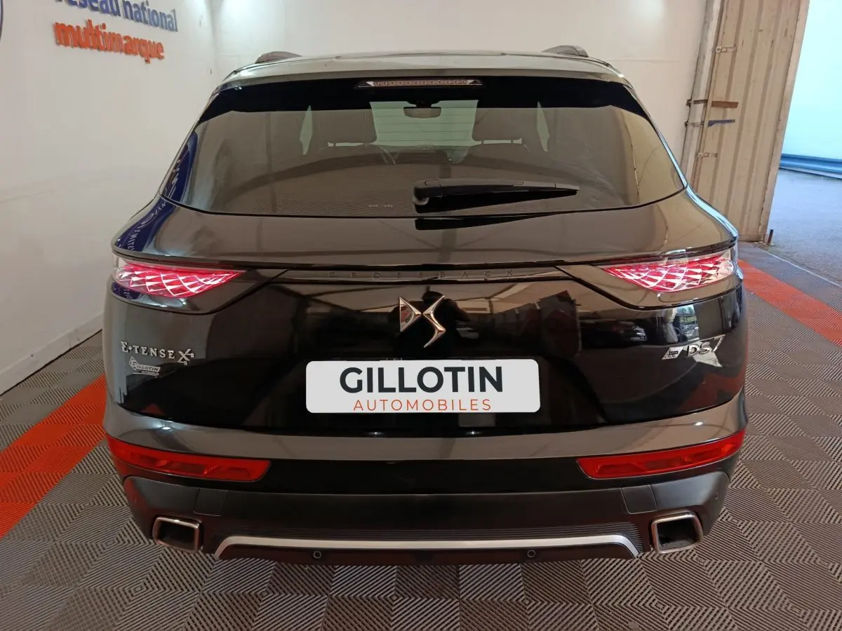 Vue arrière d'un DS7 Crossback E-TENSE 4x4 noir avec feux LED distinctifs et double sortie d'échappement carrée.