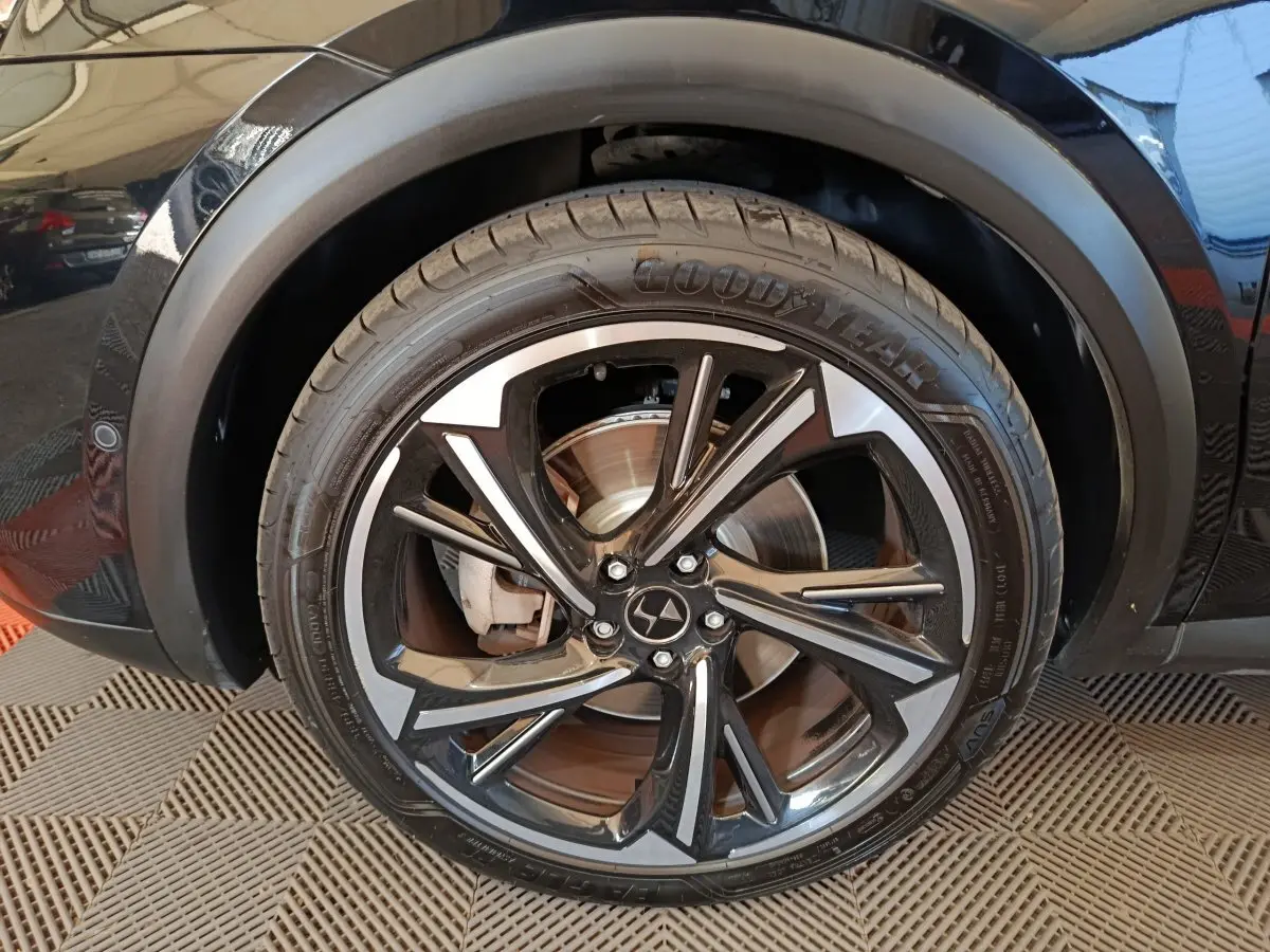 Gros plan sur la roue avant droite noire du DS7 Crossback E-TENSE 4x4 300 avec jante alliage bicolore.