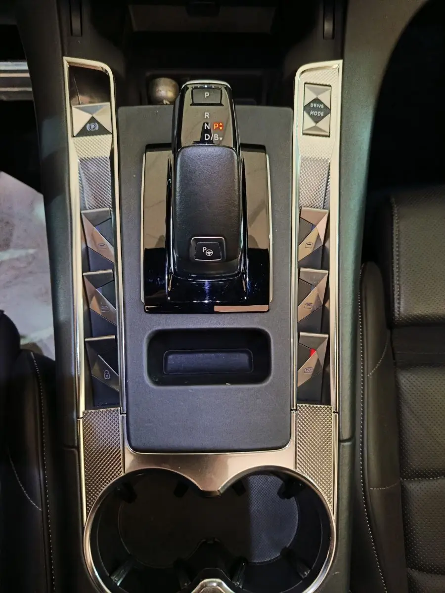 Vue plongeante sur la console centrale noire du DS7 Crossback E-TENSE 4x4 300 avec levier de vitesses et boutons triangulaires.