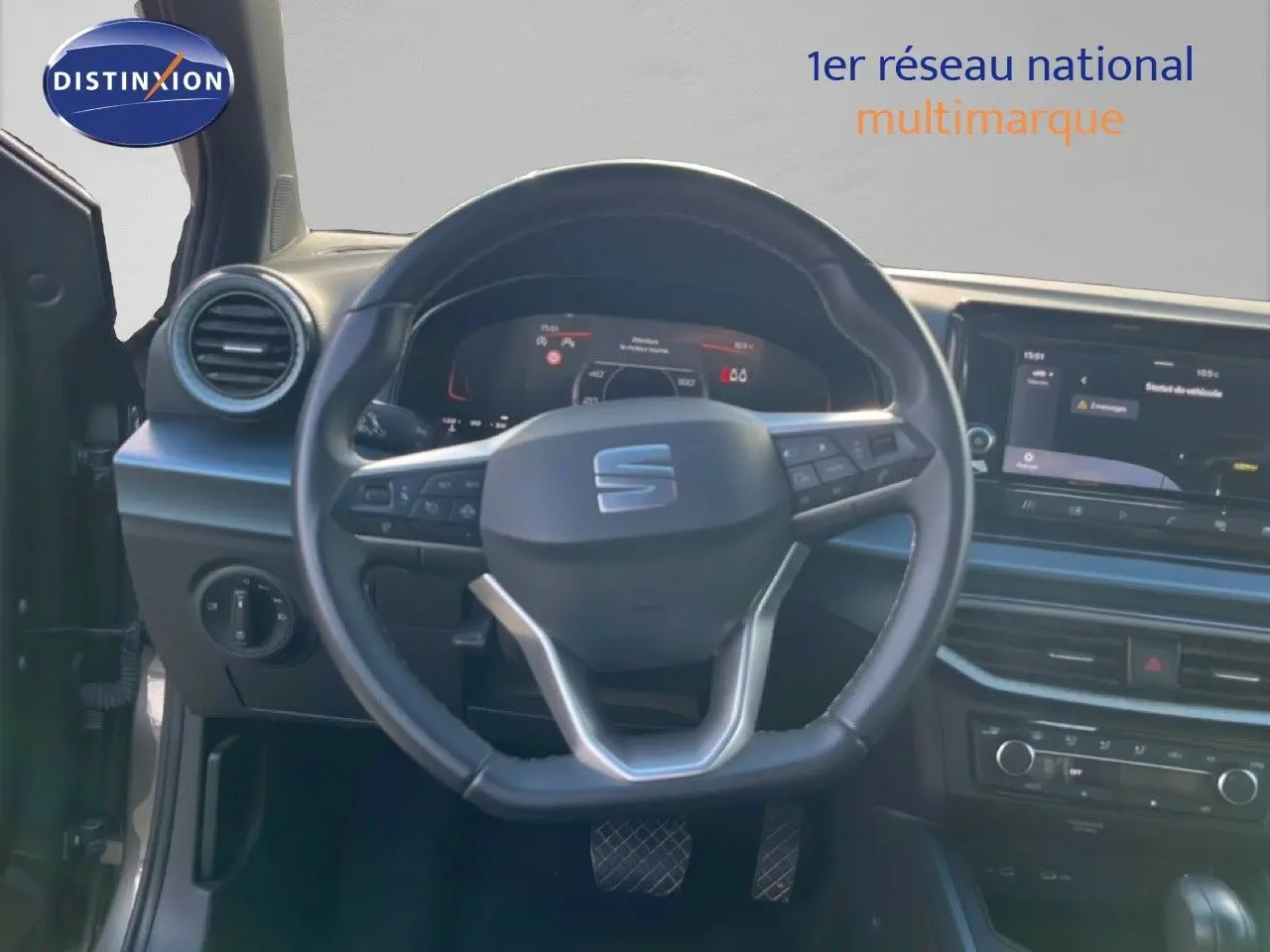 Vue intérieure centrée sur le volant cuir multifonction d'une SEAT Arona 2025, avec tableau de bord digital et écran tactile.