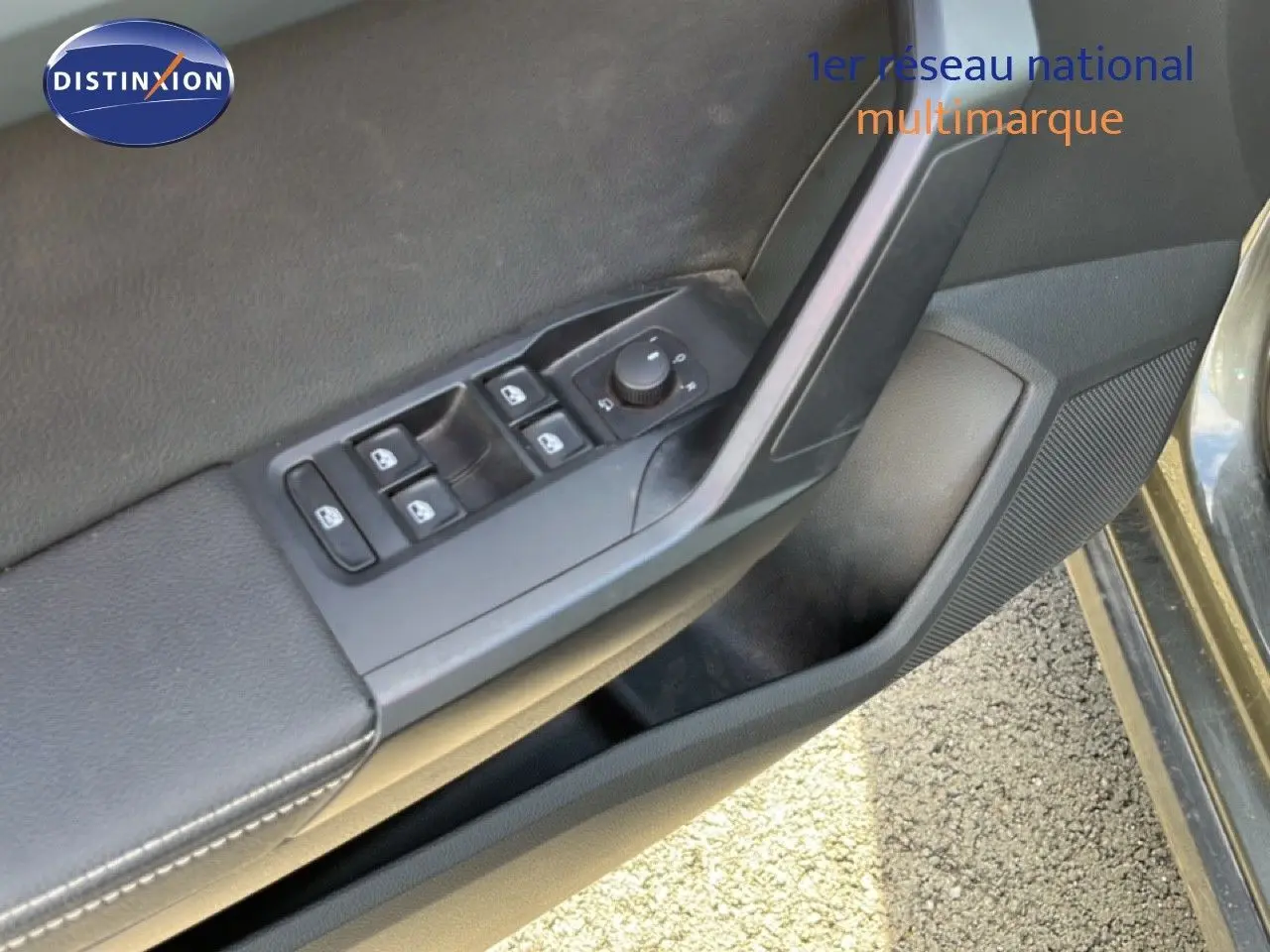 Détail intérieur côté conducteur montrant les commandes de lève-vitres et rétroviseurs d’une SEAT Arona gris magnétique.