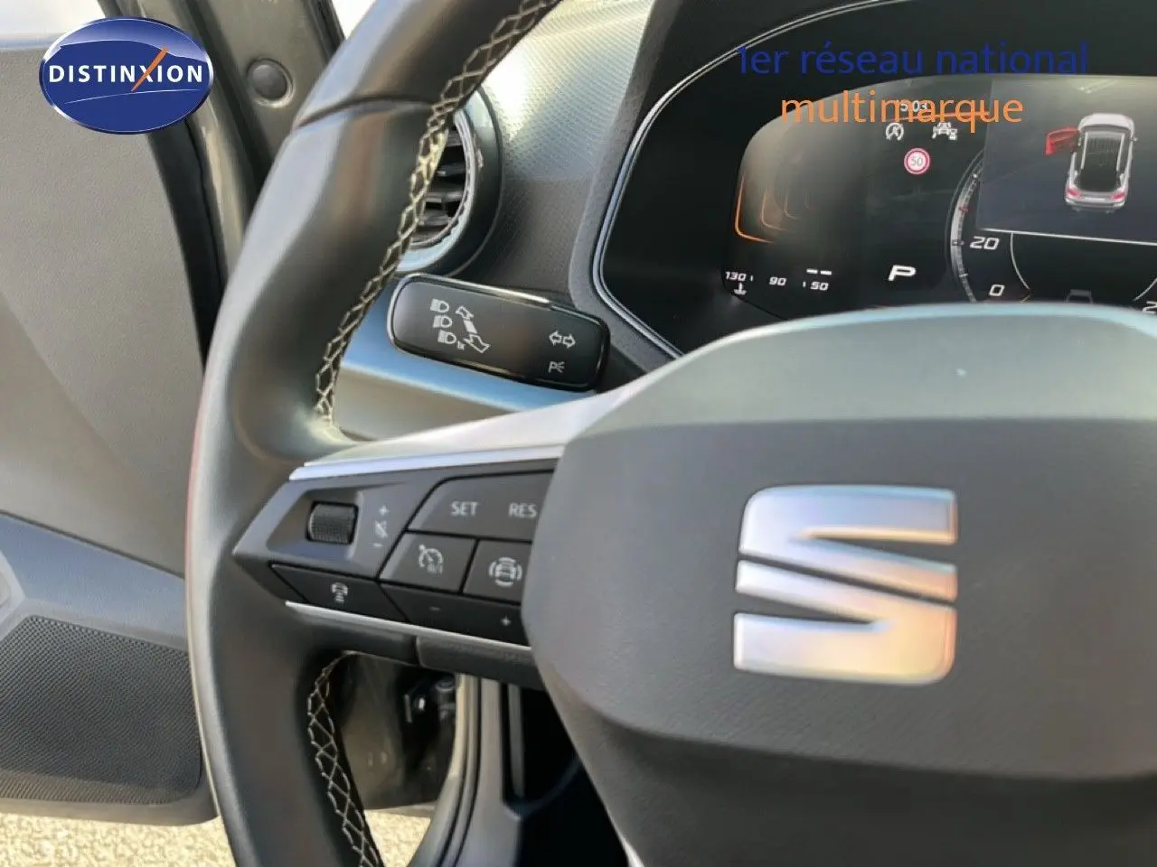 Gros plan sur le volant cuir noir de la SEAT Arona 2025 avec commandes intégrées et tableau de bord numérique.