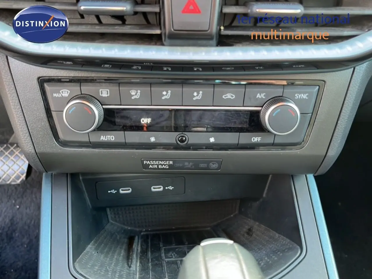 Vue rapprochée de la console centrale du SEAT Arona 2025, gris magnétique, montrant la climatisation et ports USB.