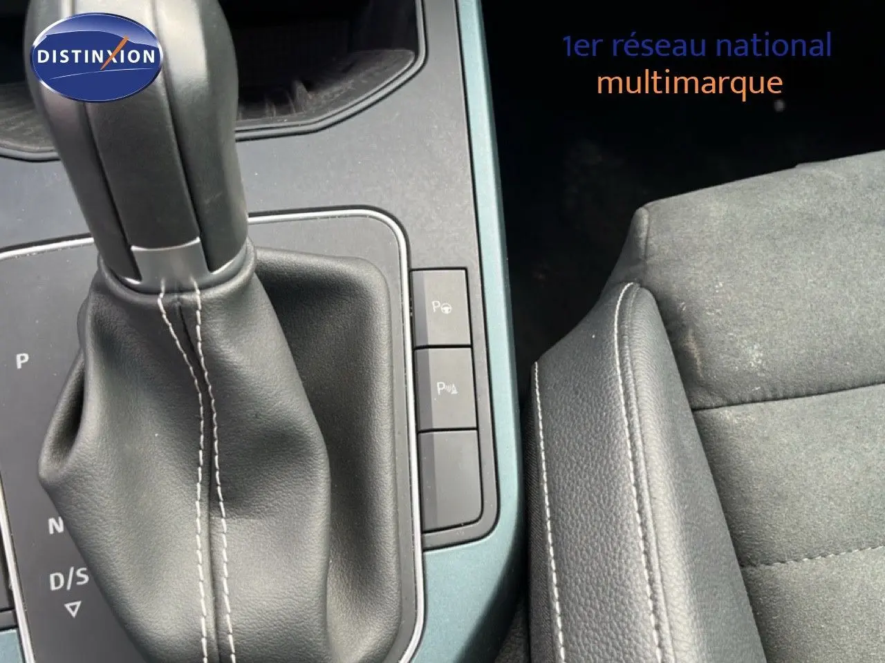 Gros plan sur la console centrale avec levier de boîte automatique et siège en tissu noir du SEAT Arona 2025.