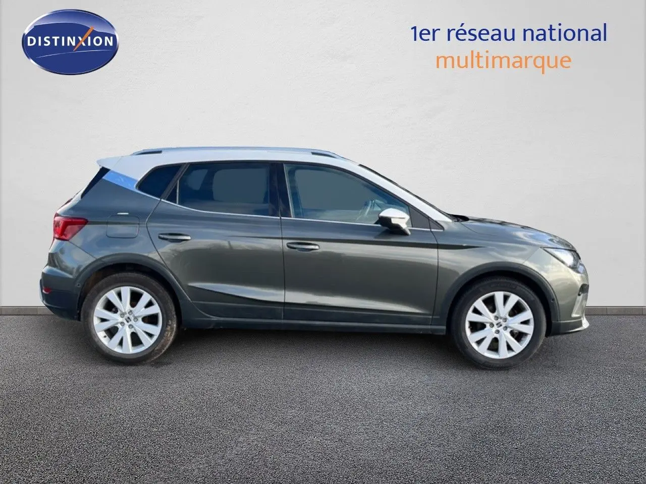 Vue de profil côté gauche d'un SEAT Arona gris magnétique avec toit blanc, sur fond neutre extérieur.