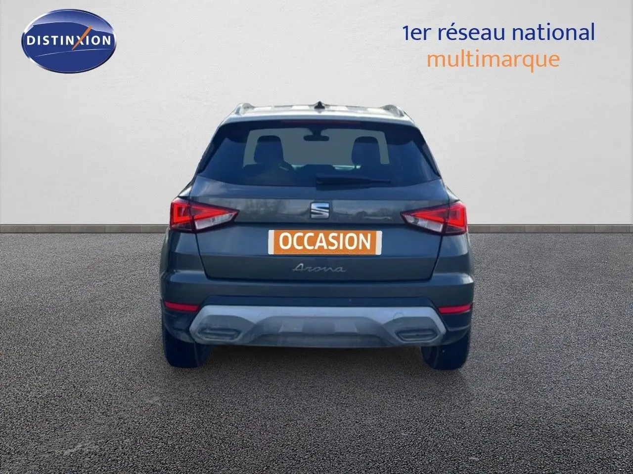 Vue arrière d'un SEAT Arona gris magnétique métal avec toit blanc, mettant en valeur ses feux arrière anguleux et son pare-chocs contrasté.