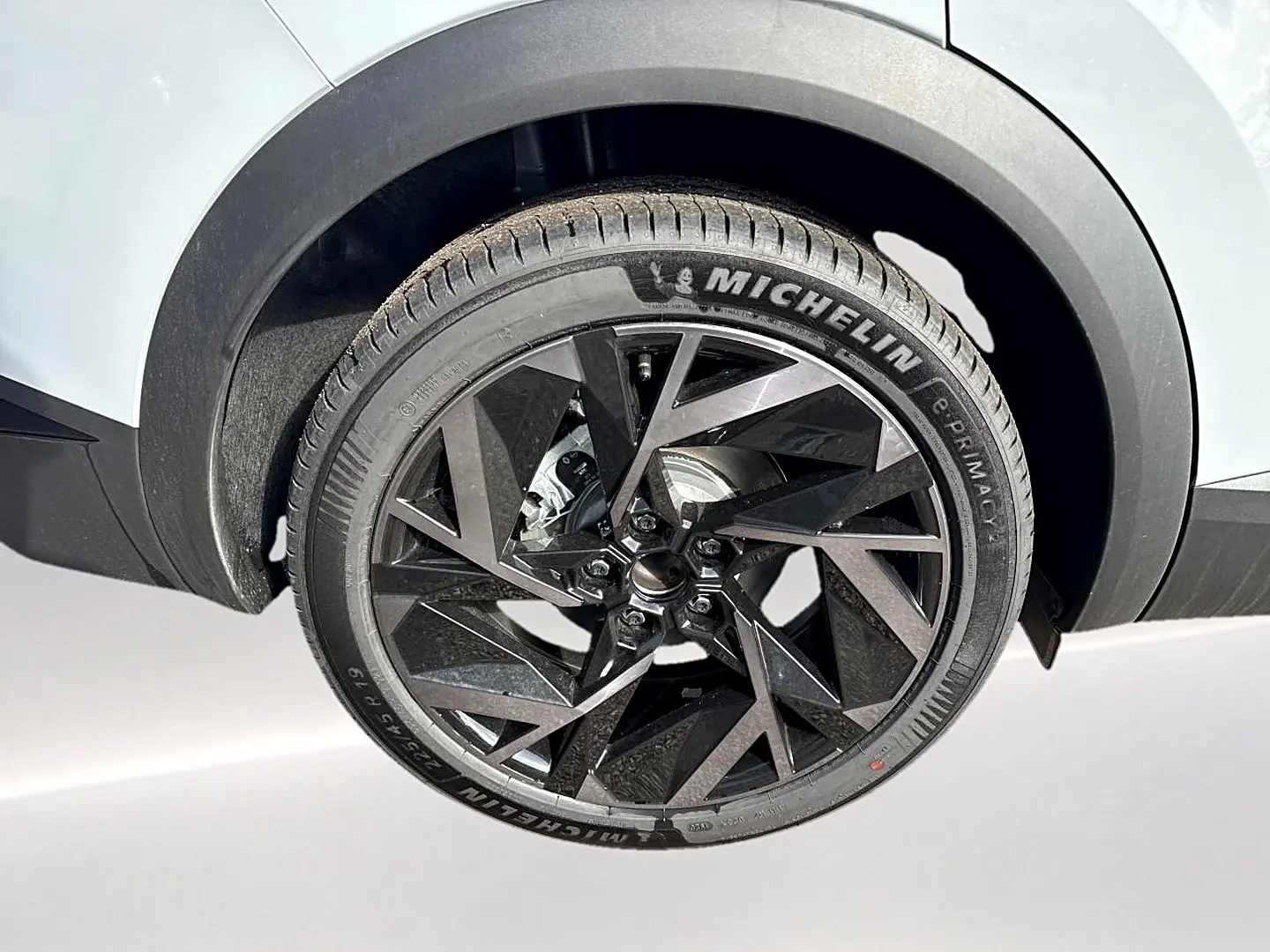 Gros plan sur la roue arrière droite gris rafale du Renault Symbioz 1.8 e-tech avec jante alu noire au design géométrique.