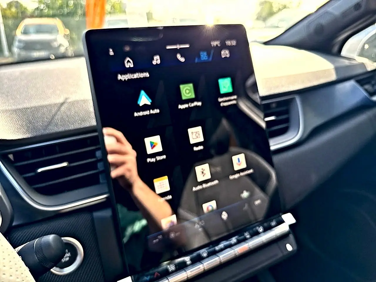 Vue intérieure du tableau de bord de la Renault Symbioz gris rafale, avec écran tactile central affichant applications connectées.