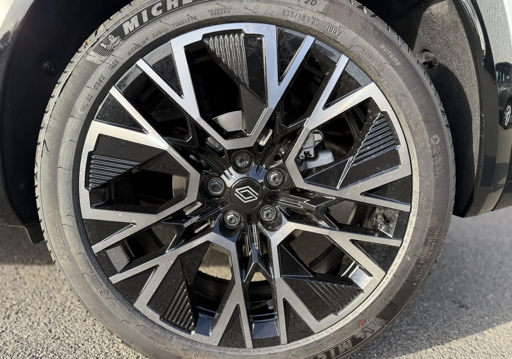 Gros plan sur la jante noire et argentée au design géométrique du Renault Austral blanc nacré 2025.