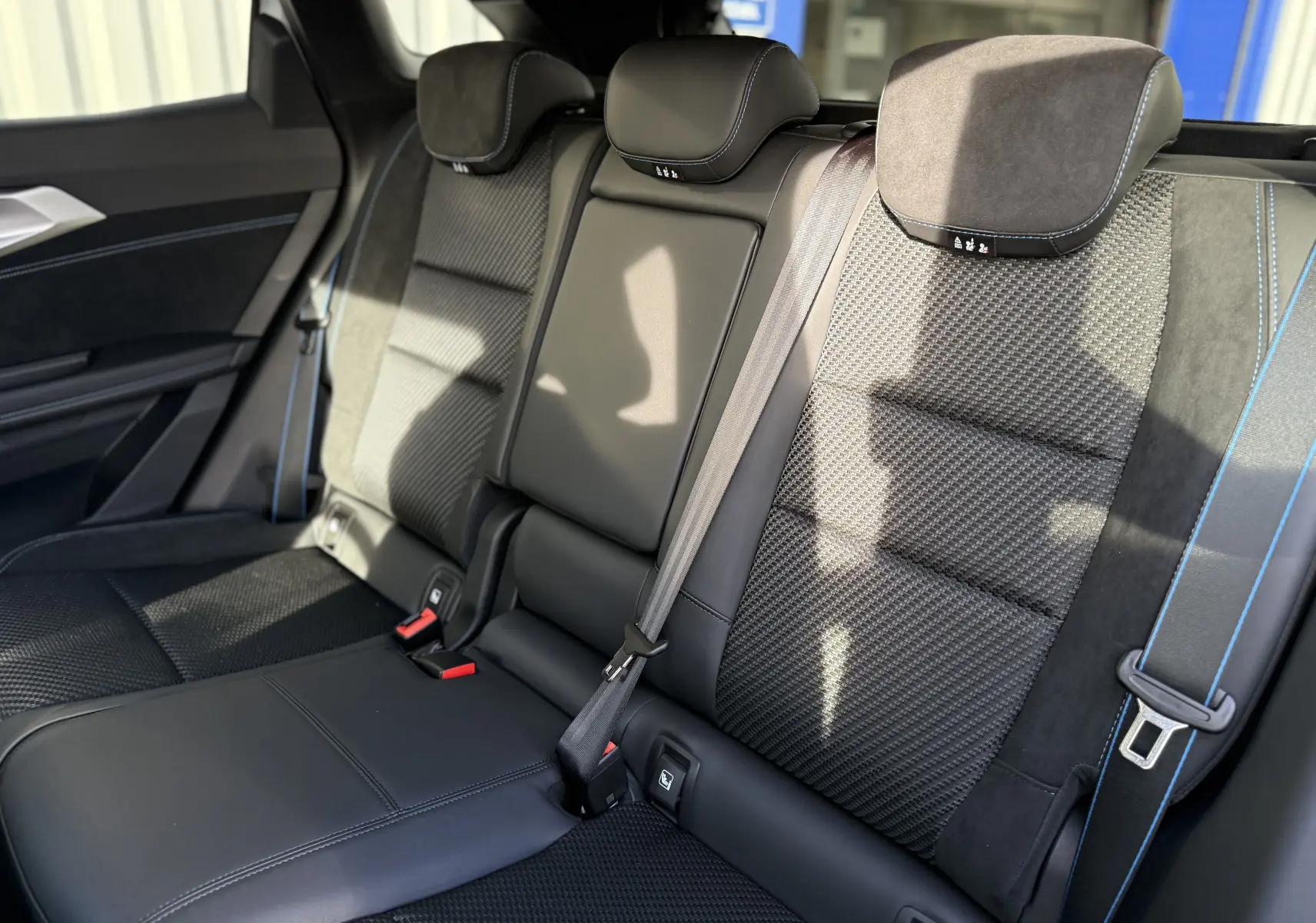 Vue intérieure des sièges arrière noirs avec surpiqûres bleues du Renault Austral 2025 version Esprit Alpine.