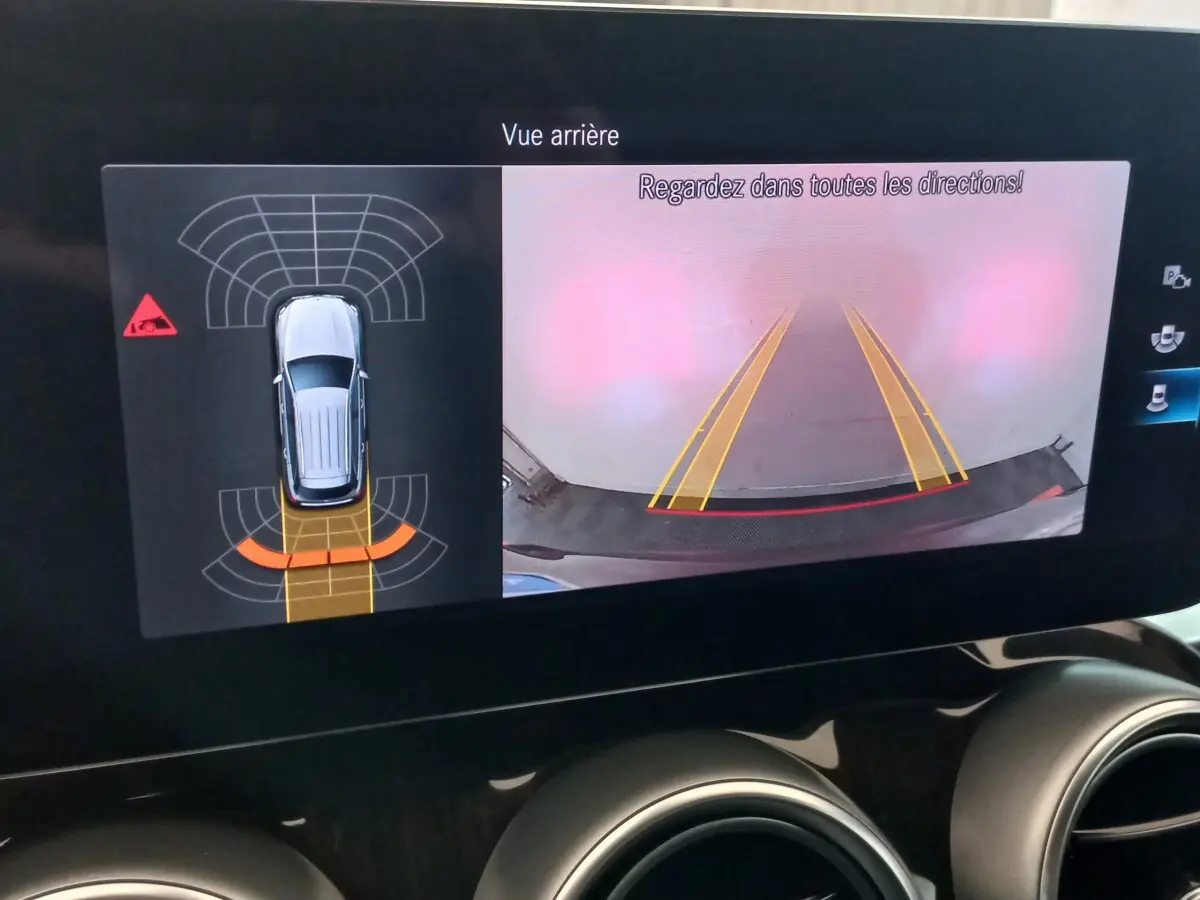 Affichage écran tactile intérieur montrant la caméra de recul et l'aide au stationnement du Mercedes GLC noir 2021.