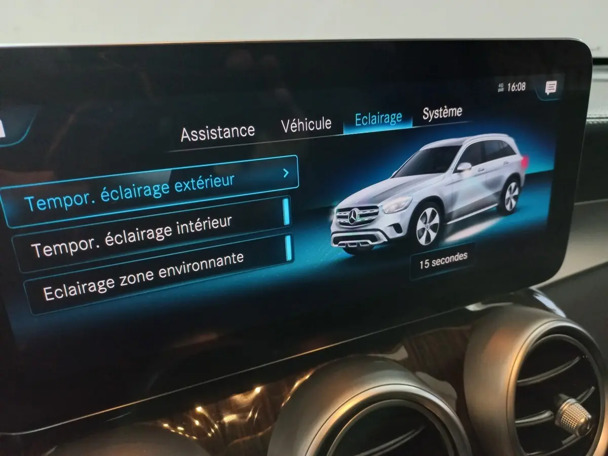Écran tactile intérieur affichant les réglages d’éclairage avec illustration d’un Mercedes GLC gris en 3/4 avant droit.