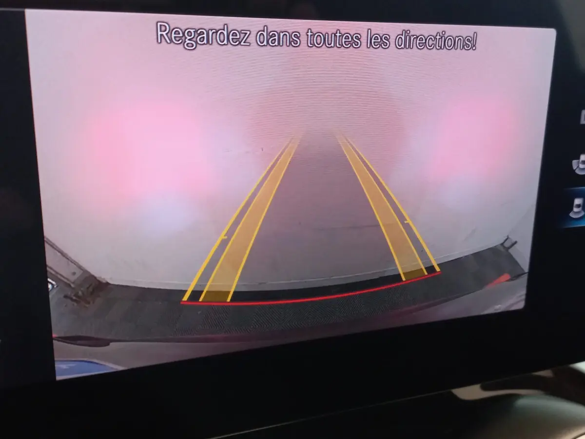 Vue caméra de recul du Mercedes GLC 300 E Business Line noir montrant les lignes de guidage jaunes et le pare-chocs arrière.