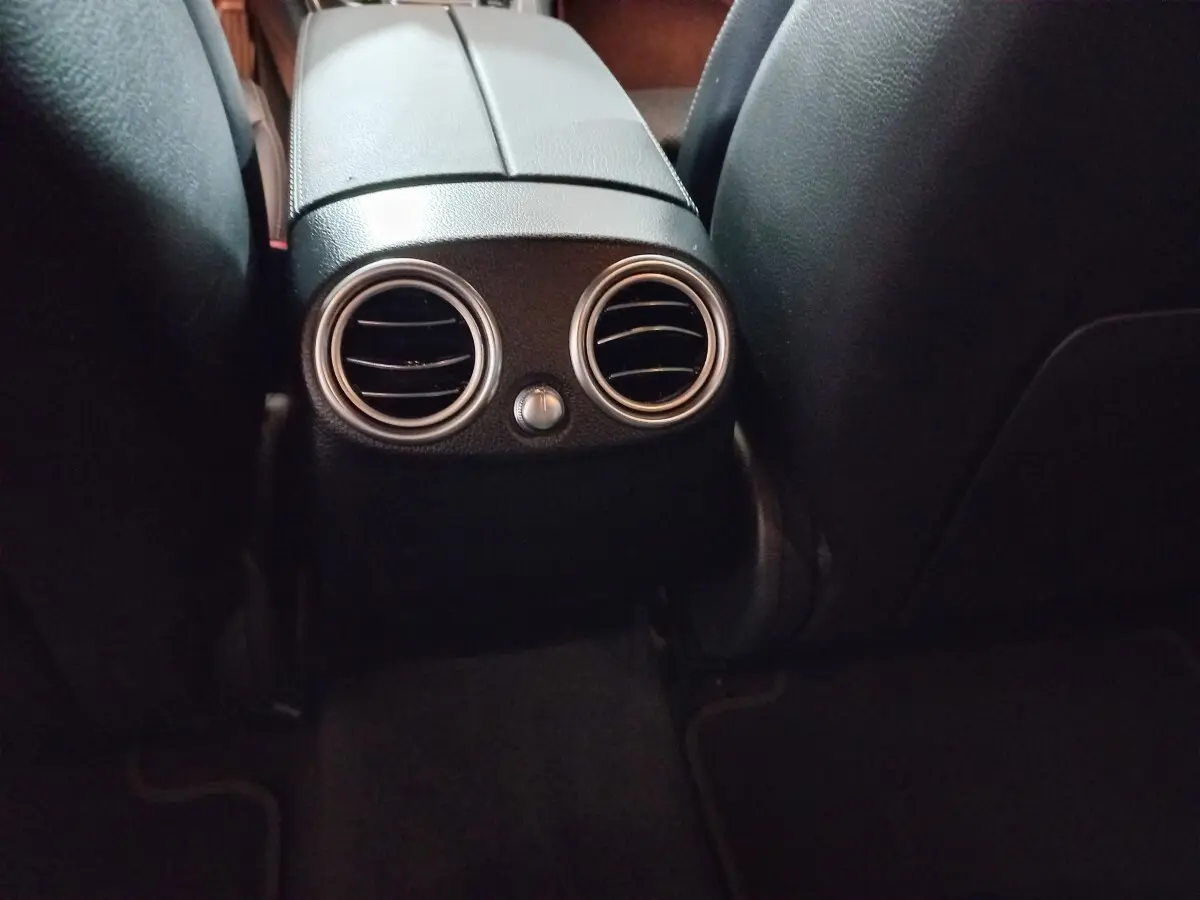 Détail des aérateurs arrière ronds chromés entre les sièges noirs du Mercedes GLC 300 E Business Line 2021.