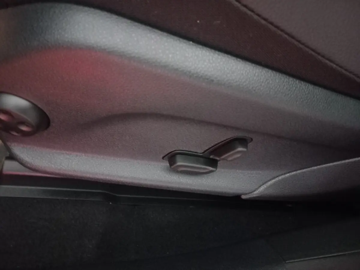 Détail des commandes de réglage manuel du siège en cuir noir dans un Mercedes GLC 300 E Business Line 2021.