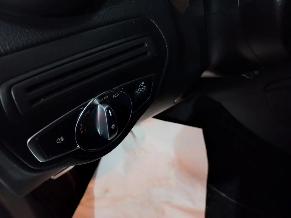 Gros plan sur la commande des phares noire dans l'habitacle du Mercedes GLC 300 E Business Line 2021.