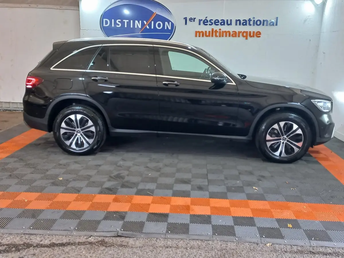 Profil droit d'un Mercedes GLC 300 E Business Line hybride rechargeable noir, roues alliage et vitres teintées.