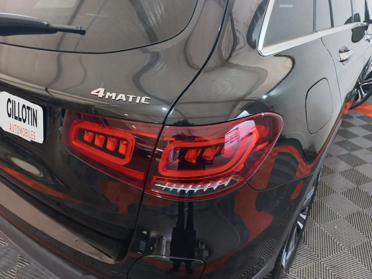 Gros plan sur l'arrière droit noir brillant d'un Mercedes GLC 300 E 4MATIC avec feux arrière LED distinctifs.