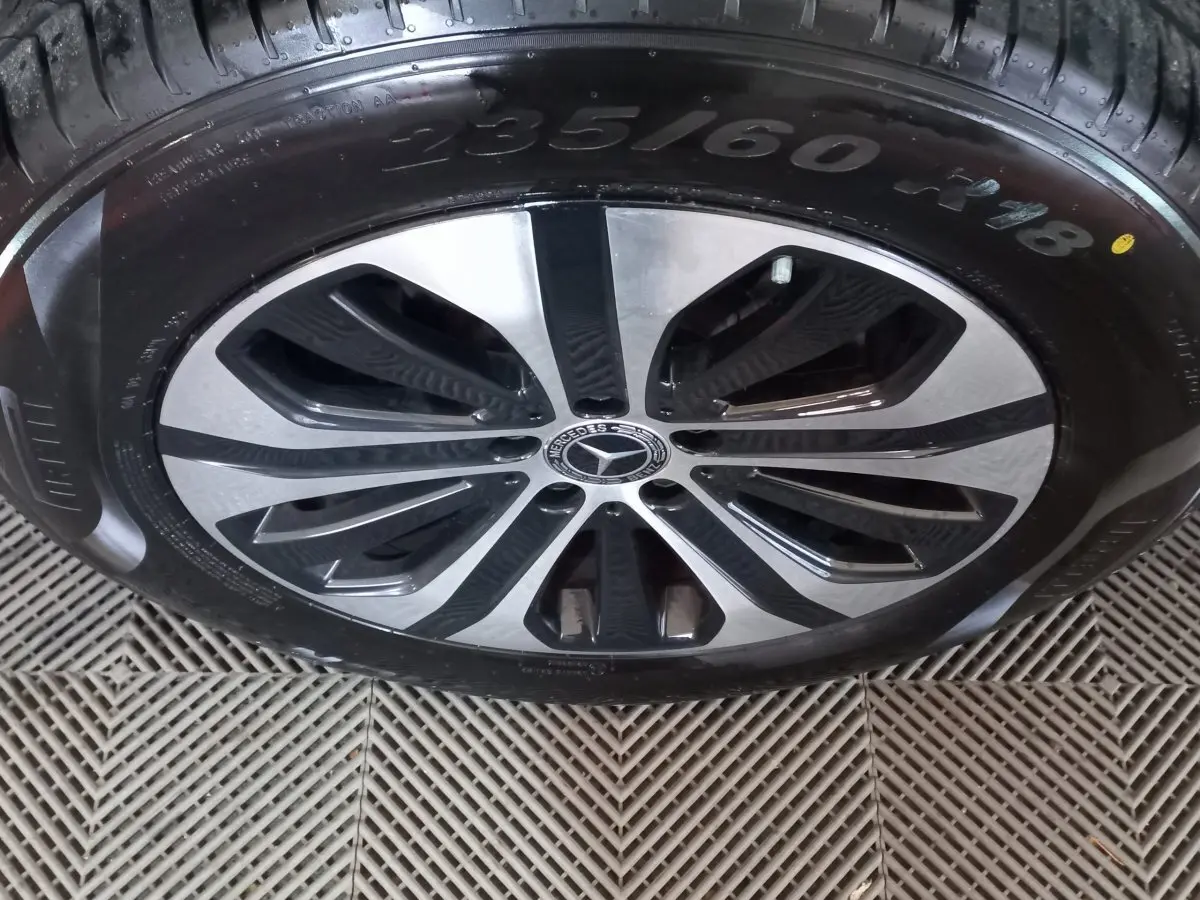 Gros plan sur la jante alliage bicolore et pneu 235/60 R18 du Mercedes GLC 300 E Business Line noir hybride rechargeable.