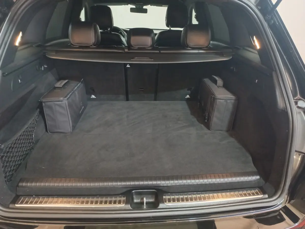 Coffre ouvert noir du Mercedes GLC 300 E Business Line 2021, vue arrière montrant espace et deux sacs noirs latéraux.