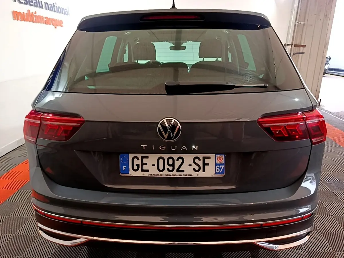 Vue arrière d’un Volkswagen Tiguan gris clair avec feux LED et plaque d’immatriculation française visible en intérieur.