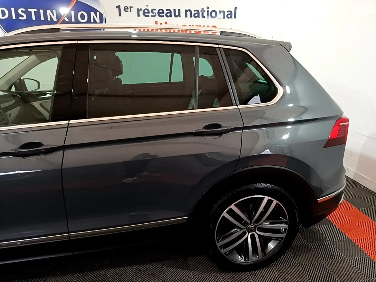 Vue latérale droite du Volkswagen Tiguan gris clair 2022, mettant en valeur les jantes alliage et les vitres teintées.
