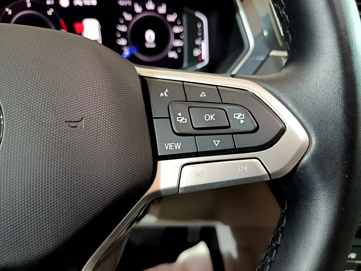 Gros plan sur les commandes multifonctions à droite du volant cuir noir du Volkswagen Tiguan 2.0 TDI 2022.