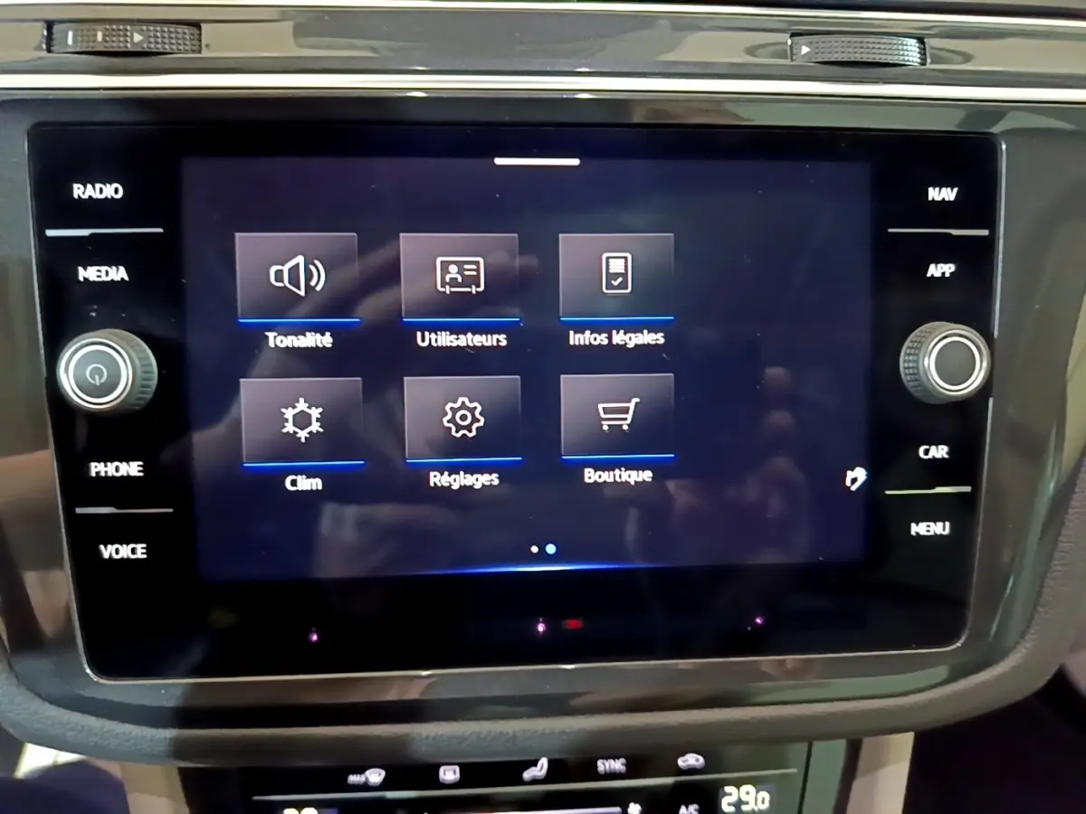 Écran tactile central du Volkswagen Tiguan gris clair 2022 affichant menu tonalité, clim, réglages et boutique.