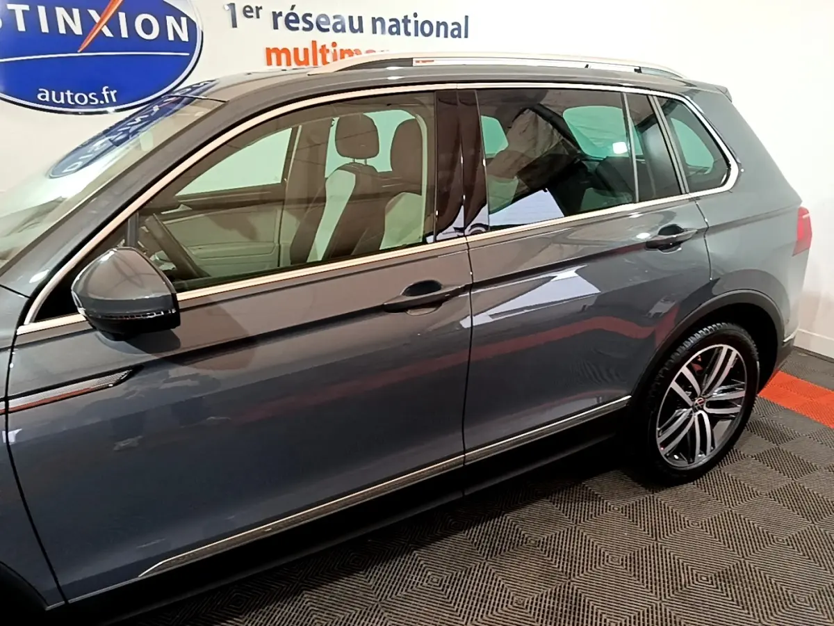 Vue latérale droite d'un Volkswagen Tiguan gris clair 2022 avec jantes alliage et rétroviseurs noirs.