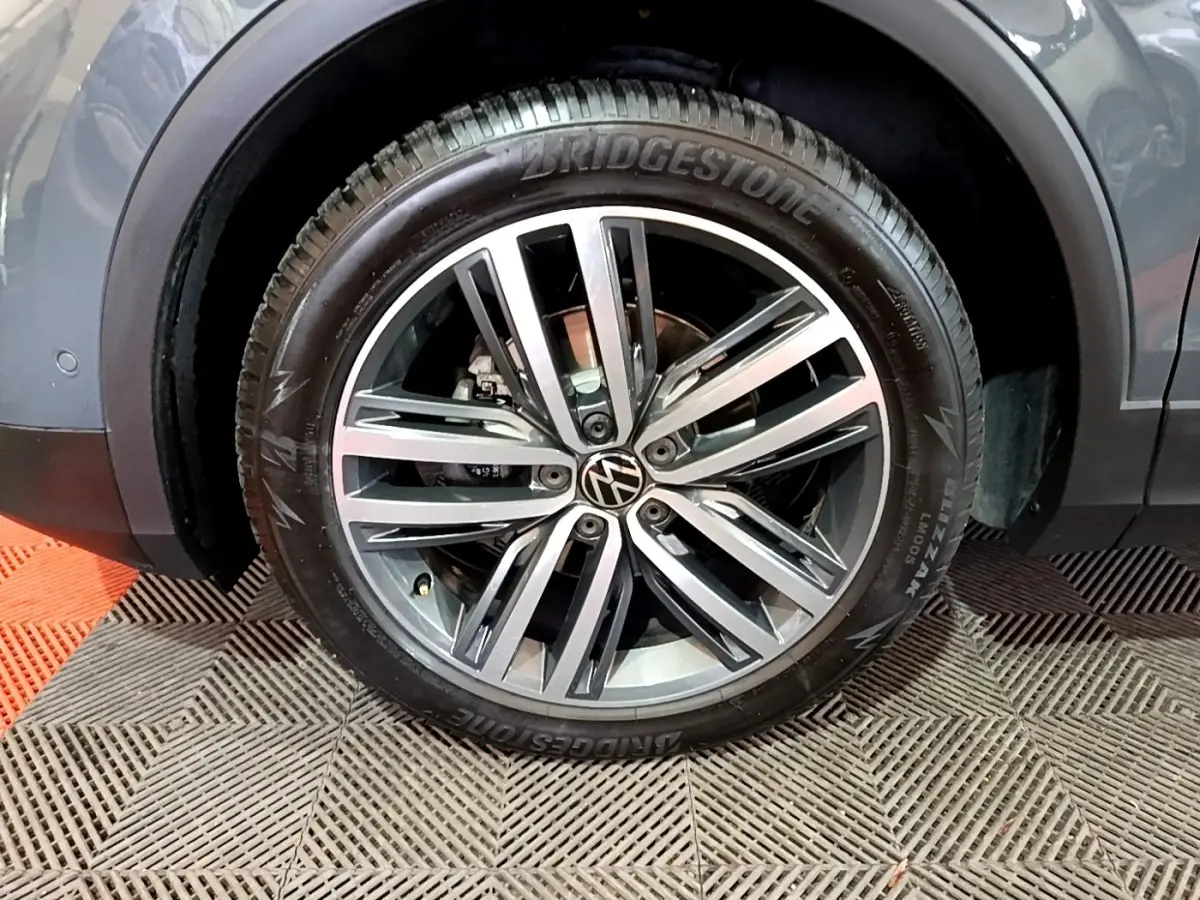 Gros plan sur la roue avant gauche gris clair du Volkswagen Tiguan 2.0 TDI avec jante alliage et pneu Bridgestone.