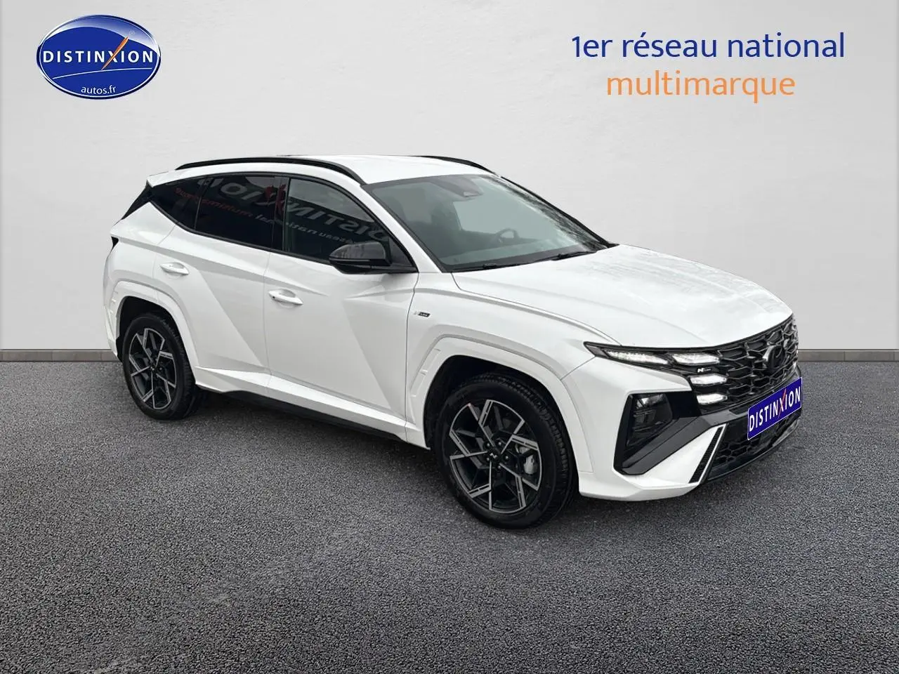 Vue 3/4 avant droite d’un Hyundai Tucson blanc sérénité avec calandre noire et jantes alliage 19 pouces.