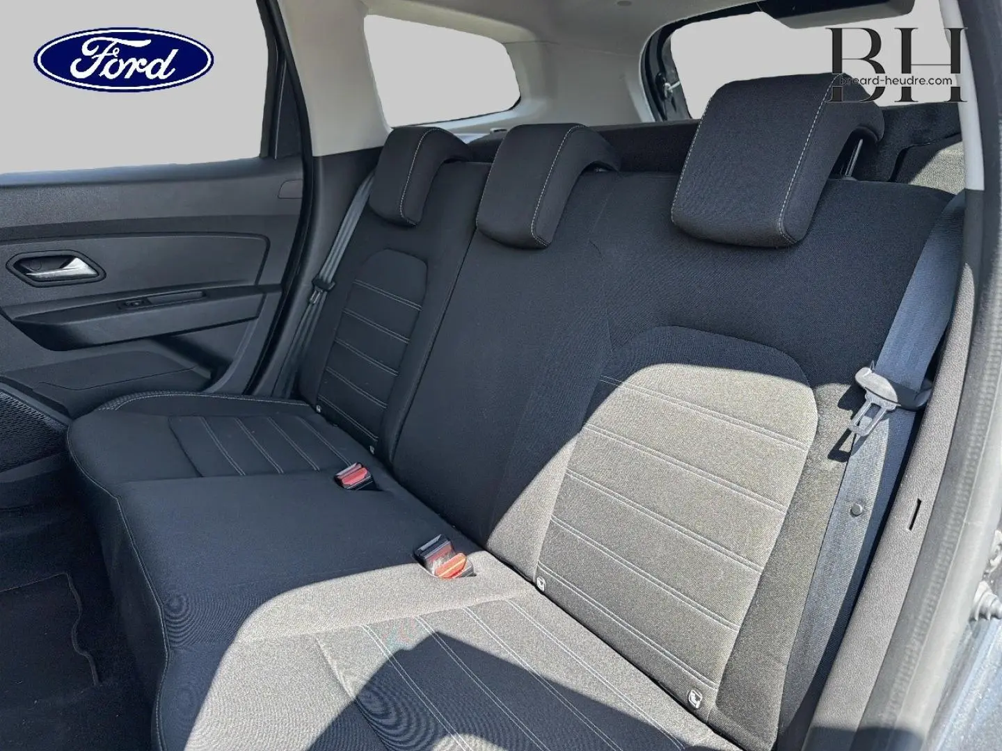 Vue latérale droite de la banquette arrière noire d'un Dacia Duster 2020 avec ceintures et appuie-têtes intégrés.