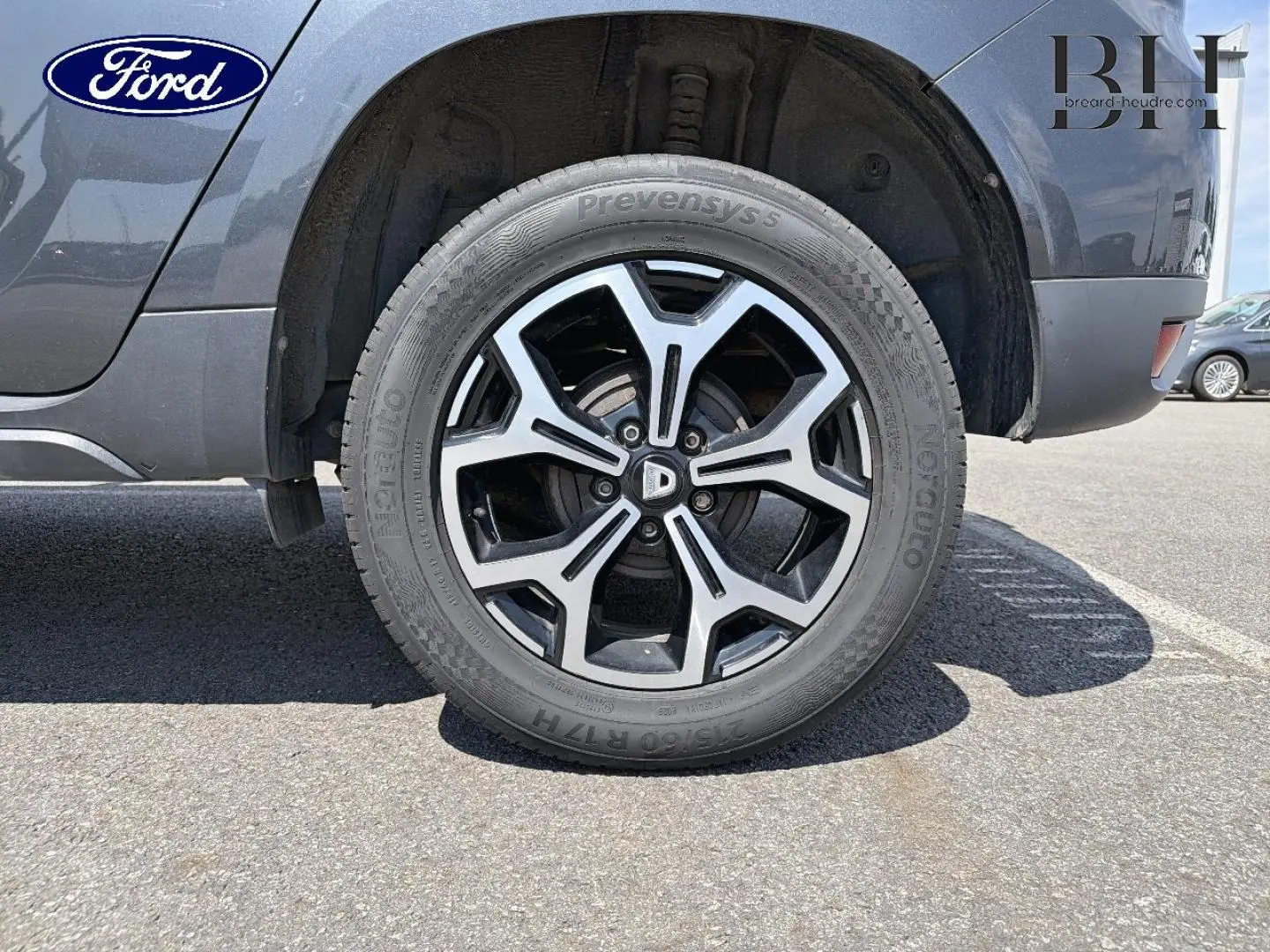 Gros plan sur la roue arrière droite du Dacia Duster gris Comète métallisé avec jante alliage distinctive.