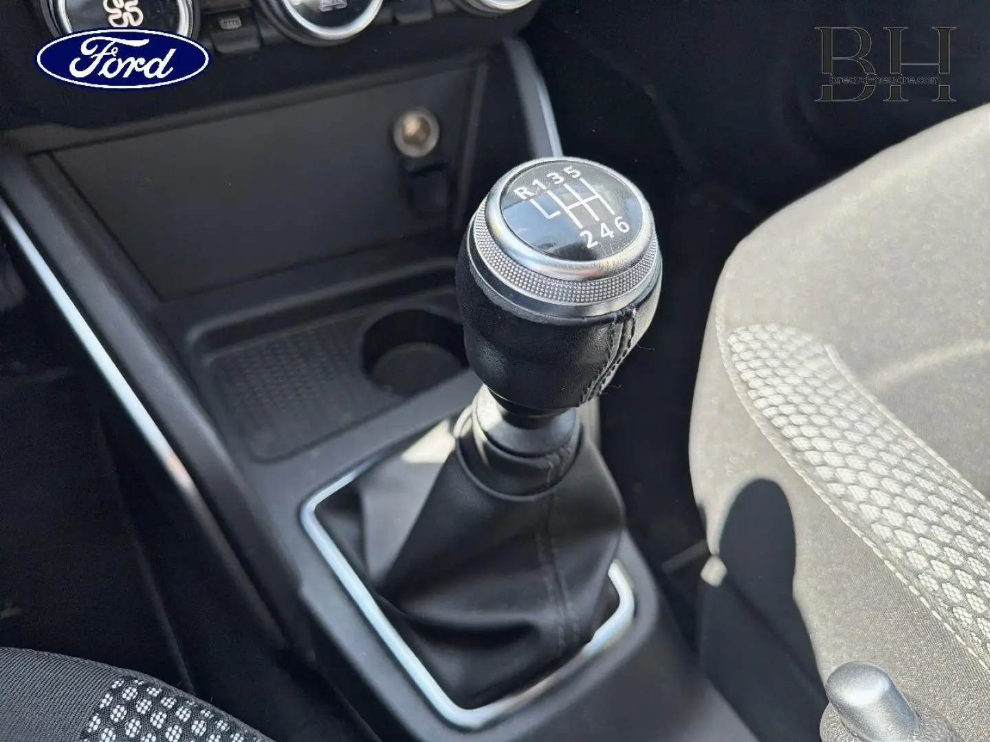 Gros plan sur le levier de vitesses manuel noir et la console centrale d’un Dacia Duster 2020, siège tissu gris visible.