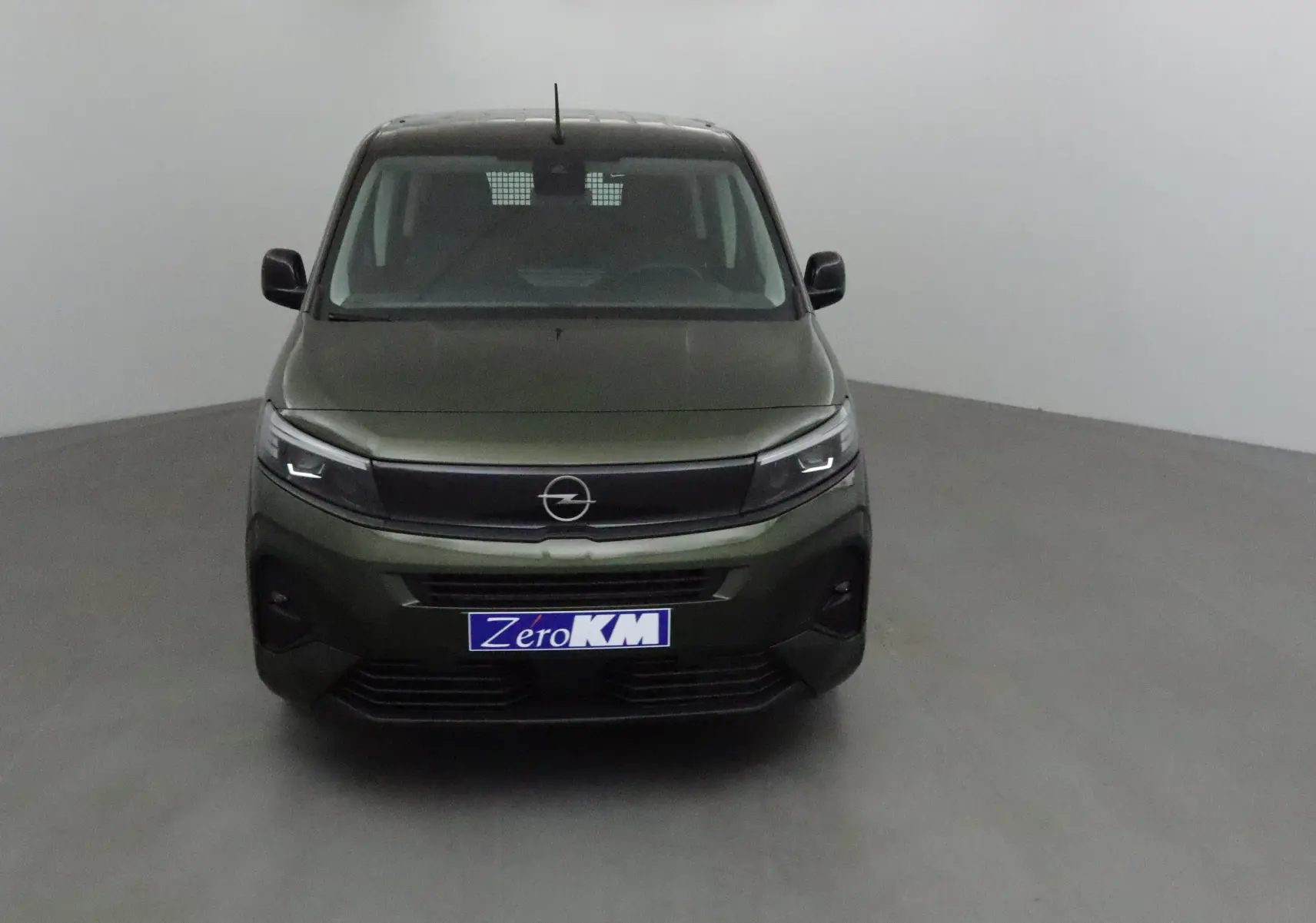 Vue frontale d'un Opel Combo Life vert Sirkka avec calandre noire et phares LED allumés dans un studio.