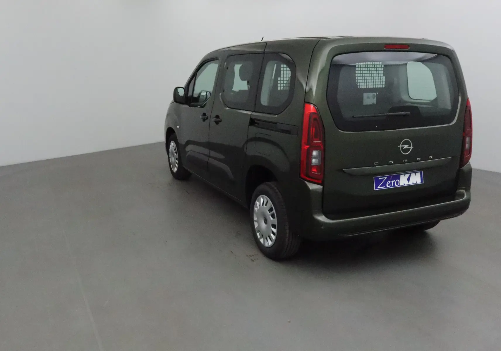 Vue 3/4 arrière droite d'un Opel Combo Life vert Sirkka avec grille de séparation visible à l'arrière.