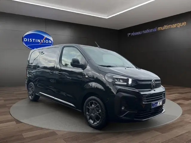 Vue 3/4 avant d'un Citroën Jumpy noir 2025, avec jantes noires et calandre moderne dans un showroom.