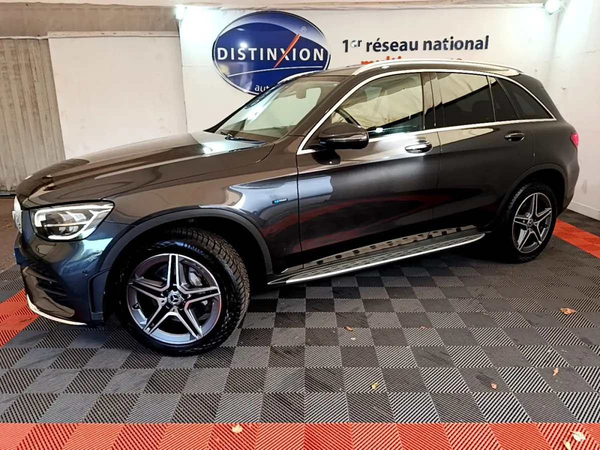 Mercedes GLC 300 E AMG Line gris foncé vu de profil côté gauche, avec jantes AMG et marchepieds chromés.