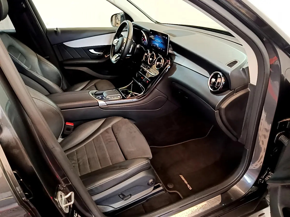 Intérieur avant droit du Mercedes GLC 300 E AMG Line 2021 avec sièges cuir noirs et tableau de bord moderne.