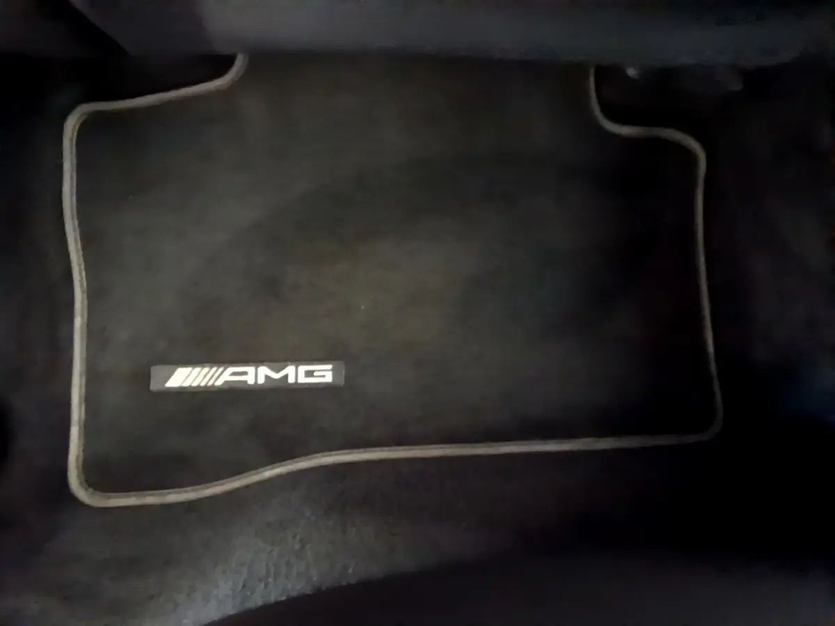 Tapis de sol noir avec logo AMG visible, intérieur du Mercedes GLC 300 E AMG Line hybride rechargeable 2021.