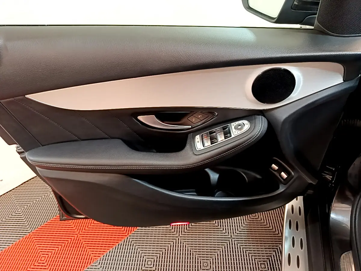 Intérieur côté conducteur de la porte d'une Mercedes GLC 300 E AMG Line 2021 gris foncé, avec commandes électriques et haut-parleur intégré.