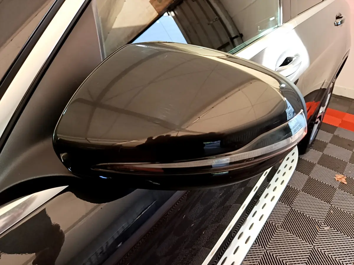 Gros plan sur le rétroviseur droit noir brillant du Mercedes GLC 300 E AMG Line gris foncé, vue latérale partielle.