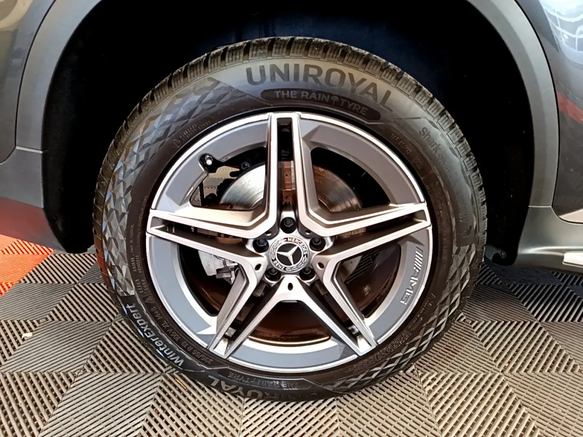 Gros plan sur la roue AMG avec jante étoile grise du Mercedes GLC 300 E hybride gris foncé, côté gauche visible.