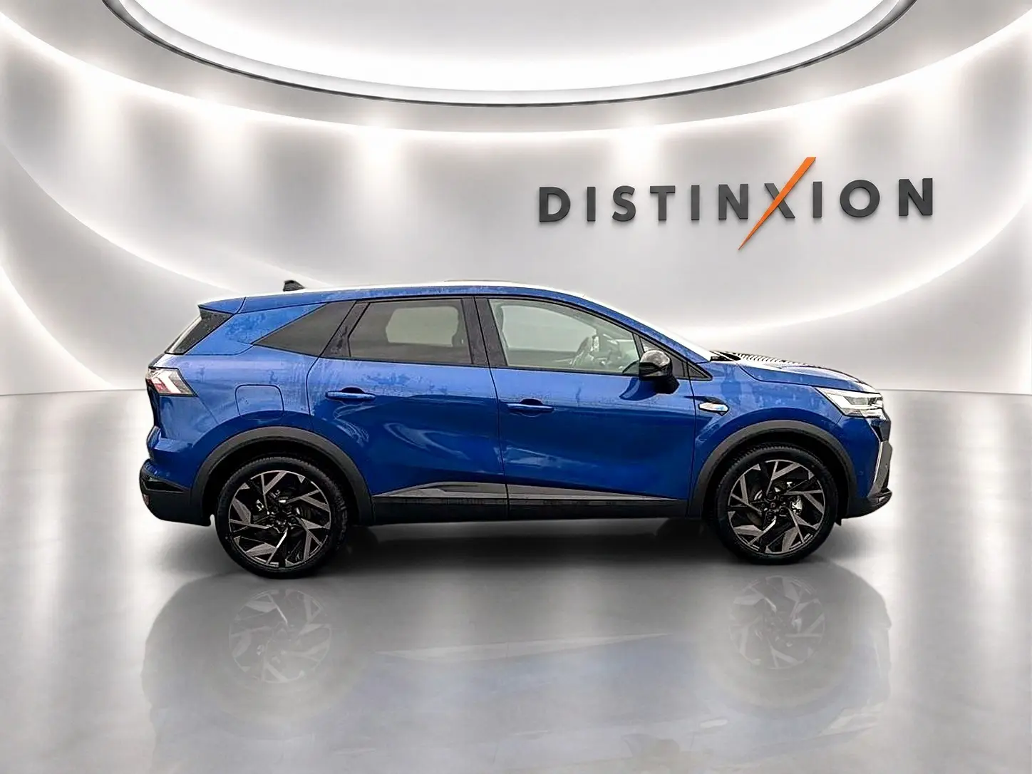 Profil droit du Renault Symbioz 2026 bleu iron avec jantes alu noires et toit noir dans un studio lumineux.